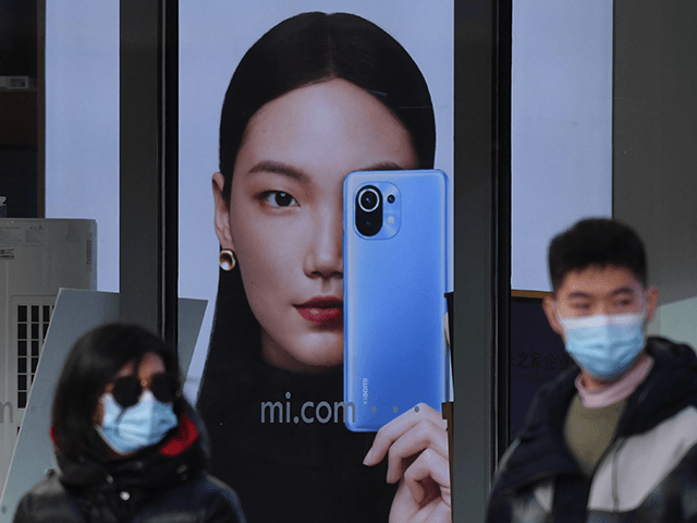 People walk past a Xiaomi store in Beijing on January 15, 2021, as shares in the company collapsed on January 15 after the United States blacklisted the smartphone giant and a host of other Chinese firms. (Photo by GREG BAKER / AFP) (Photo by GREG BAKER/AFP via Getty Images)