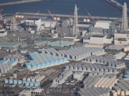 TOPSHOT - This picture taken on February 14, 2021 shows an aerial view of the TEPCO's Fukushima Daiichi Nuclear Power Plant (top) undergoing decommissioning work and tanks (bottom) for storing treated water. - - Japan OUT (Photo by STR / JIJI PRESS / AFP) / Japan OUT (Photo by STR/JIJI …