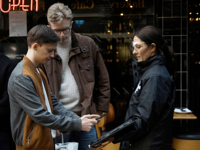 A customer uses their phone to scan a QR code for the NHS Test and Trace, as thye prepare to take a table at a bar in the Soho area of London, on April 16, 2021 following step two of the government's roadmap out of England's third national lockdown. - …