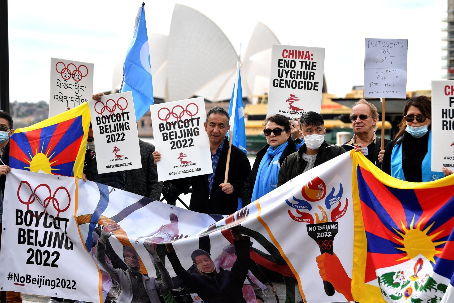 Protesters hold up placards and banners as they attend a demonstration in Sydney on June 23, 2021 to call on the Australian government to boycott the 2022 Beijing Winter Olympics over China's human rights record. (Photo by Saeed KHAN / AFP) (Photo by SAEED KHAN/AFP via Getty Images)
