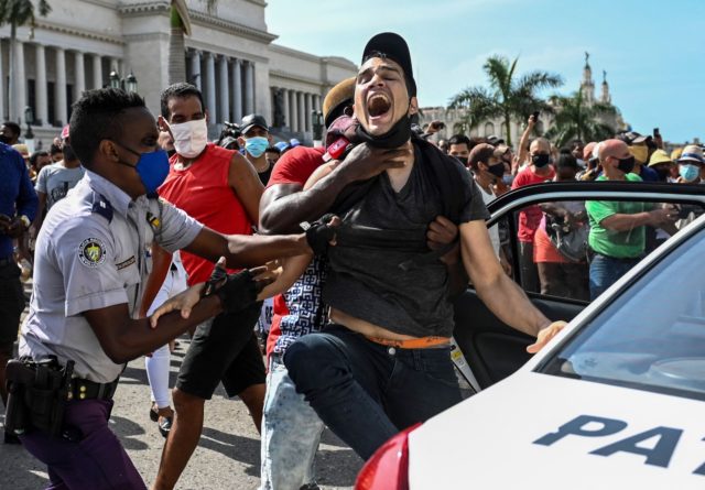 A man is arrested during a demonstration against the government of Cuban President Miguel Diaz-Canel in Havana, on July 11, 2021. - Thousands of Cubans took part in rare protests Sunday against the communist government, marching through a town chanting "Down with the dictatorship" and "We want liberty." (Photo by …