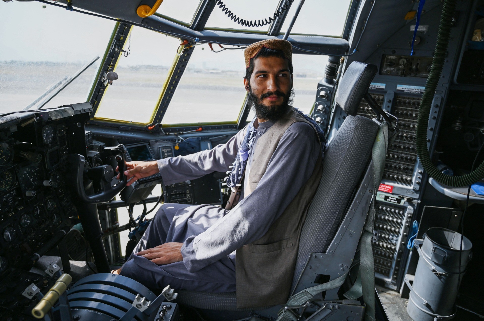 TOPSHOT - A Taliban fighter sits in the cockpit of an Afghan Air Force aircraft at the airport in Kabul on August 31, 2021, after the US has pulled all its troops out of the country to end a brutal 20-year war -- one that started and ended with the hardline Islamist in power. (Photo by Wakil KOHSAR / AFP) (Photo by WAKIL KOHSAR/AFP via Getty Images)