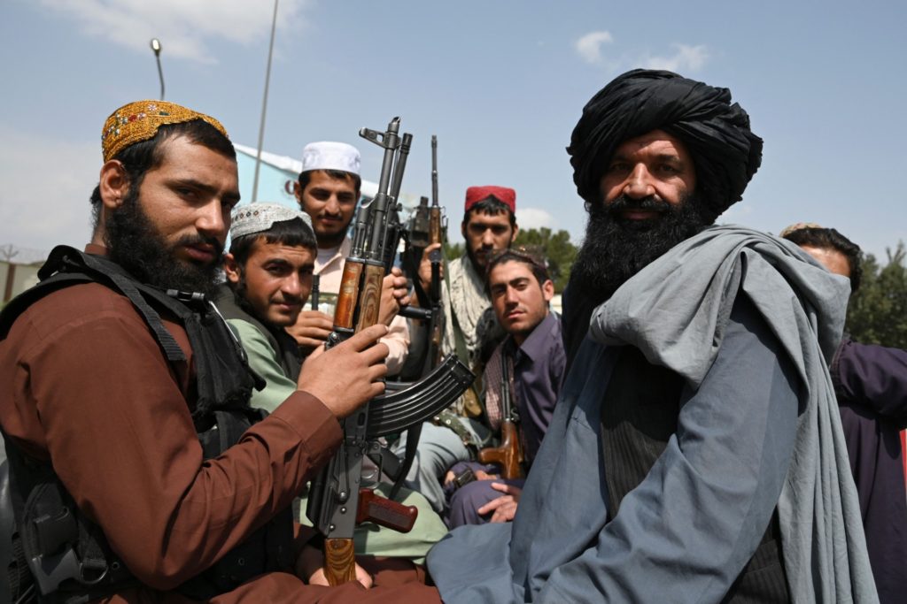Taliban fighters sit on the back of a pick-up truck at the airport in Kabul on August 31, 2021, after the US has pulled all its troops out of the country to end a brutal 20-year war -- one that started and ended with the hardline Islamist in power. (Photo by WAKIL KOHSAR / AFP) (Photo by WAKIL KOHSAR/AFP via Getty Images)
