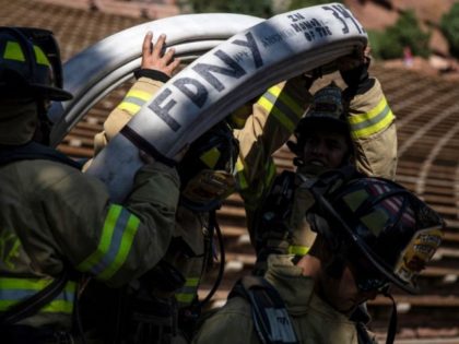 Firefighters in full gear carry a fire hose in honor of the NYFD as they, along with first responders, victims family members and supporters, participate in the 2021 Colorado 9/11 Memorial Stair Climb at the Red Rocks Park and Amphitheatre on September 11, 2021 in Morrison, outside Denver, Colorado. - …