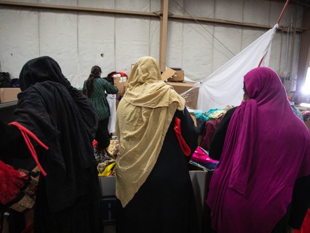 FORT MCCOY, WI - SEPTEMBER 30: Afghan Refugees look for donated clothing and shoes at the donation center at Fort McCoy, U.S. Army Base In Wisconsin. There are approximately 12,600 Afghan refugees being cared for under ‘Operation Allies Welcome’ in Fort McCoy, Wisconsin September 30, 2021. The Department of Defense, …