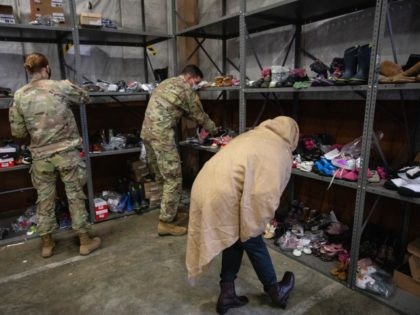 FORT MCCOY, WI - SEPTEMBER 30: An Afghan refugee looks for donated shoes at the donation c