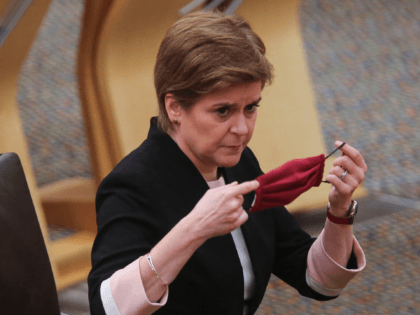 EDINBURGH, SCOTLAND - OCTOBER 5: Scotland's First Minister Nicola Sturgeon adjusts her face mask during updates to MSPs on any changes to the Covid-19 restrictions at the Scottish Parliament on October 5, 2021 in Edinburgh, Scotland. (Photo by Fraser Bremner - Pool/Getty Images)