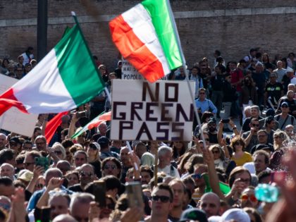 People wave national flags during a protest against the mandatory sanitary pass called "green pass" in the aim to limit the spread of the Covid-19 in central Rome on October 9, 2021. (Photo by Tiziana FABI / AFP) (Photo by TIZIANA FABI/AFP via Getty Images)