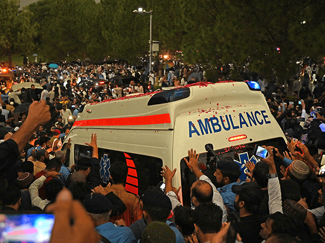 Supporters and officials gather around an ambulance carrying the coffin of the late Pakistan's nuclear scientist Abdul Qadeer Khan for his funeral outside the Faisal Mosque following his death in Islamabad on October 10, 2021. (Photo by Aamir QURESHI / AFP) (Photo by AAMIR QURESHI/AFP via Getty Images)