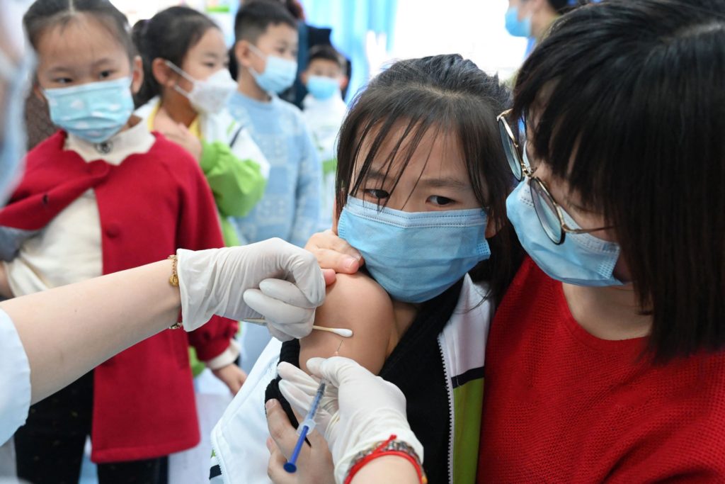 A child receives the Covid-19 coronavirus vaccine at a school in Handan, in China's northern Hebi province on October 27, 2021, after the city began vaccinating children between the ages of 3 to 11. - China OUT (Photo by AFP) / China OUT (Photo by -/AFP via Getty Images)