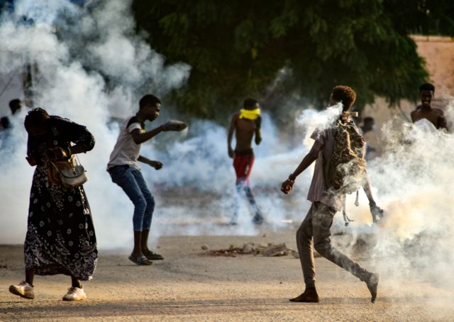 Sudanese youths confront security forces amidst tear gas fired by them to disperse protesters in the capital Khartoum, on October 27, 2021, amid ongoing demonstrations against a military takeover that has sparked widespread international condemnation. - Security forces today made sweeping arrests of protesters who kept up demonstrations in the …
