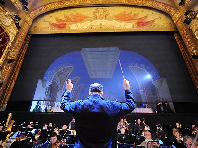 The conductor's assistant (C) guides the orchestra during sound check before a dress rehea