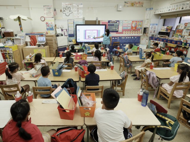 NEW YORK, NEW YORK - JULY 22: Melissa Moy, a teacher at Yung Wing School P.S. 124, goes over a lesson on a monitor with in-person Summer program students on July 22, 2021 in New York City. Positive COVID-19 cases in some New York City public schools have resulted in …