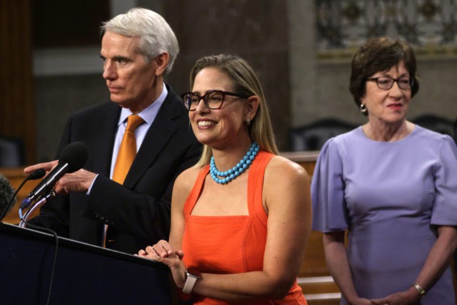 WASHINGTON, DC - JULY 28: U.S. Sen. Rob Portman (R-OH) (L) and Sen. Kyrsten Sinema (D-AZ) (2nd L) answer questions from members of the press as Sen. Susan Collins (R-ME) looks on during a news conference after a procedural vote for the bipartisan infrastructure framework at Dirksen Senate Office Building …