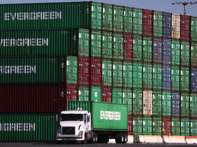 SAN PEDRO, CALIFORNIA - OCTOBER 15: A truck drives past cargo containers stacked at the Po