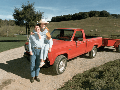February 1985: A full-length portrait of United States president Ronald Reagan and First Lady Nancy Reagan, who is sitting on the hood of a red 1985 Ford Ranger pick-up truck with her arms around her husband, at their ranch (Rancho del Cielo) near Santa Barbara, California. (Photo by Hulton Archive/Getty …