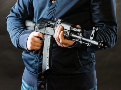 terrorist holding kalashnikov rifle isolated on a black background