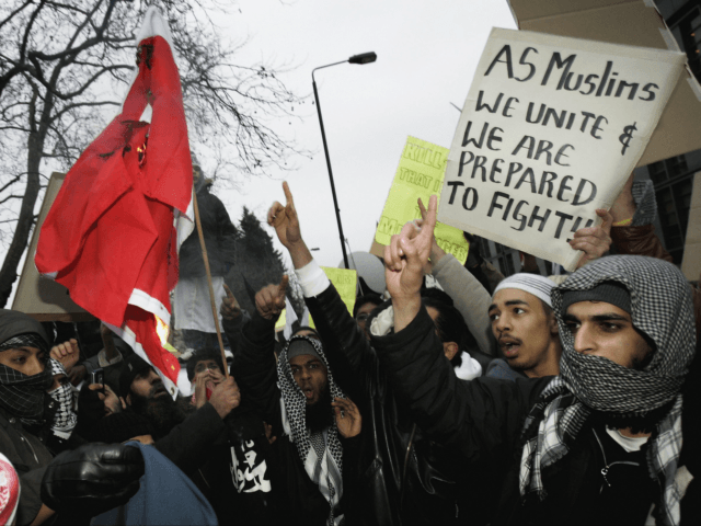 LONDON - FEBRUARY 03: Muslims burn a Danish Flag outside the Danish Embassy on FEBRUARY 3, 2006 in London, England. British muslims have condemned newspaper cartoons which first appeared in a Danish newspaper, some of which depict the Prophet Mohammed wearing a turban shaped like a bomb. The cartoons have …