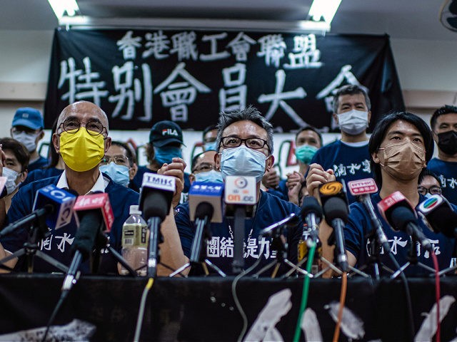 HONG KONG, CHINA - OCTOBER 03: Members of the Hong Kong Confederation of Trade Unions (HKCTU) hold their hands while to talking to the media after the union voted to disband at an emergency general assembly on October 03, 2021 in Hong Kong, China. The Hong Kong Confederation of Trade …