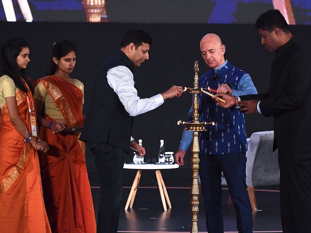 CEO of Amazon Jeff Bezos (R) lights a traditional lamp along with Amit Agarwal (3L), senior vice president and country manager for Amazon India, during the Amazon's annual Smbhav event in New Delhi on January 15, 2020. (Photo by Sajjad Hussain/AFP via Getty Images)