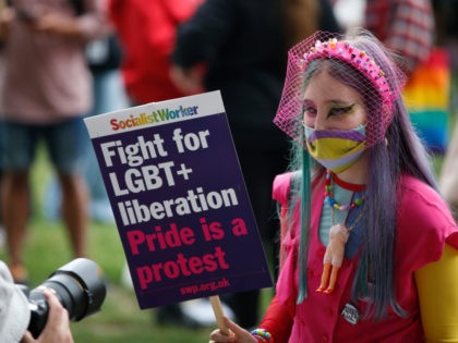 LONDON, ENGLAND - JULY 24: A demonstrator holds a placard while being photographed during a Reclaim Pride March on July 24, 2021 in London, England. The march replaces the Pride in London parade which has been postponed. (Photo by Hollie Adams/Getty Images)