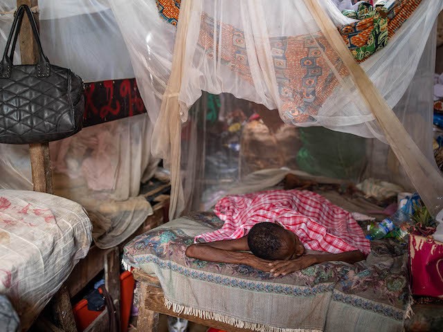 A woman, suffering from malaria, rests on her families bed inside the Povoado slum on January 27, 2020 in Luanda, Angola. (Luke Dray/Getty Images)