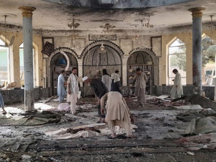 Afghans inspect the inside of a mosque following a bombing in Kunduz province northern Afghanistan, Friday, Oct. 8, 2021. A powerful explosion in a mosque frequented by a Muslim religious minority in northern Afghanistan on Friday has left several casualties, witnesses and the Taliban's spokesman said. (AP Photo/Abdullah Sahil)