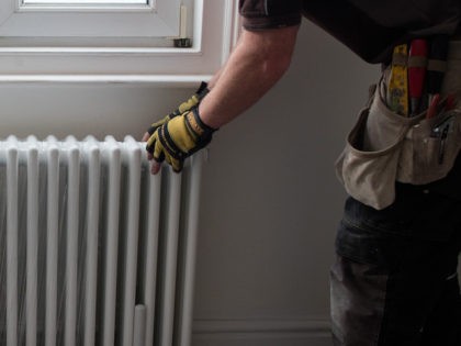 A builder fits a radiator to the wall at a residential development on October 8, 2015 in Bristol, England. (Matt Cardy/Getty Images)