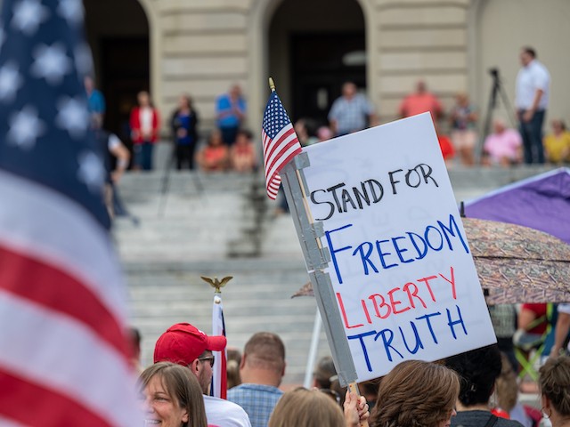 People display signs during the Kentucky Freedom Rally at the capitol building on August 28, 2021 in Frankfort, Kentucky. (Jon Cherry/Getty Images)