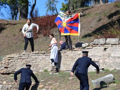 Protesters holding the Tibetan flag crash the flame lighting ceremony for the Beijing 2022 Winter Olympics at the Ancient Olympia archeological site, birthplace of the ancient Olympics in southern Greece on October 18, 2021. (Aris Messinis/AFP via Getty Images)