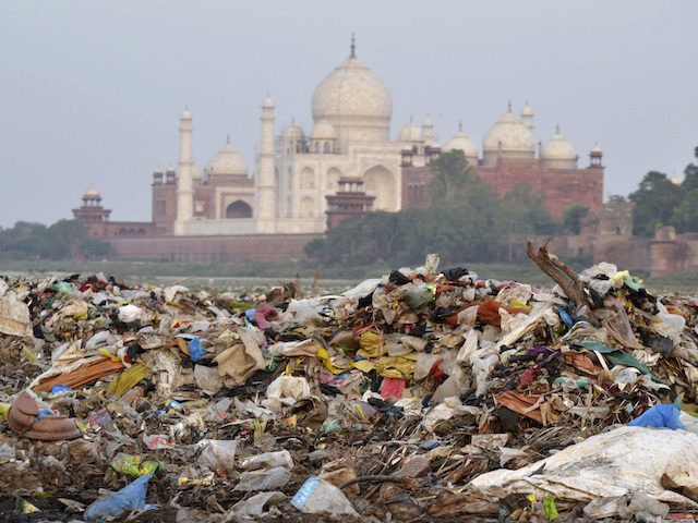 In this May 11, 2018 photo, garbage covers the area by the Yamuna river near the Taj Mahal