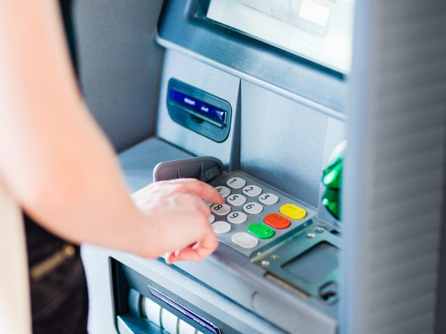 Woman enters PIN at ATM