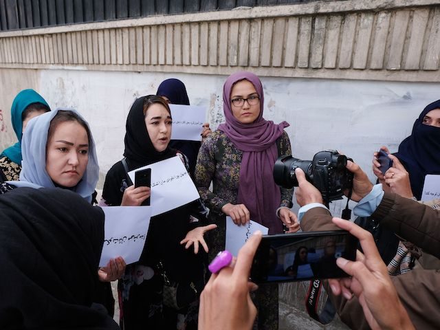 Women hold placards during a protest in Kabul on October 26, 2021, calling for the international community to speak out in support of Afghans living under Taliban rule. (James Edgar/AFP via Getty Images)