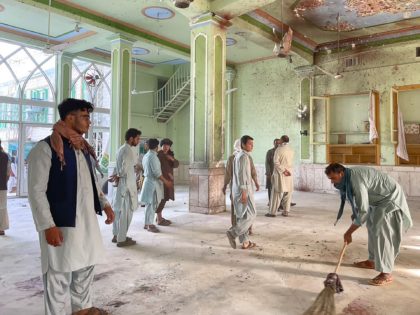 TOPSHOT - Afghan men inspect the damages inside a Shiite mosque in Kandahar on October 15,