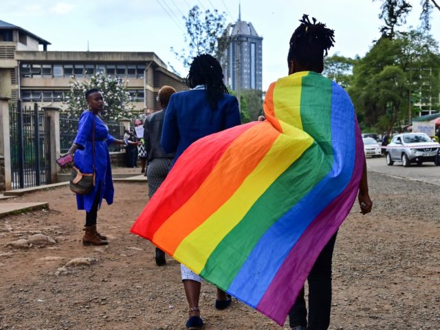 An LGBTQ community member wearing a rainbow flag leaves the Milimani high court in Nairobi, Kenya, after the verdict on scrapping laws criminalising homosexuality, on May 24, 2019. - Kenya's high court, in a much-awaited verdict, refused on May 24, 2019 to scrap laws criminalising homosexuality, fearing this would lead …