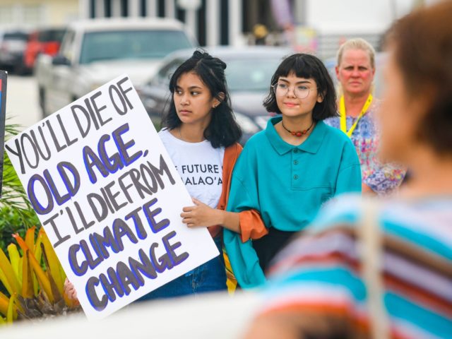 Supporters carry signs during a rally, hosted by the Micronesia Climate Change Alliance, t
