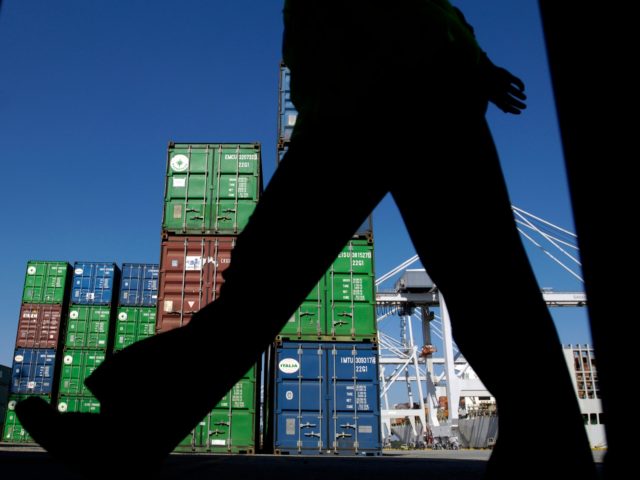 SAVANNAH, GEORGIA - OCTOBER 29: A worker walks past shipping containers at the Georgia Por