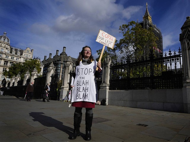 A lone climate demonstrator holds a banner outside parliament in London, Monday, Oct. 25, 2021, ahead of the UN climate conference COP26 that will be held in Glasgow, Scotland, next week. (AP Photo/Kirsty Wigglesworth)