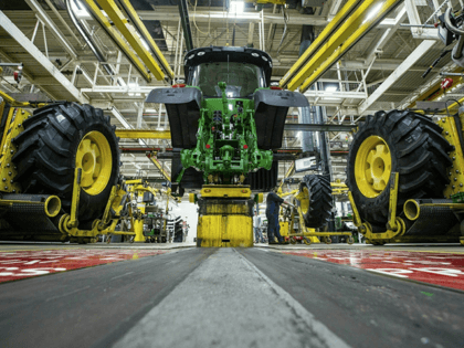 In this April 9, 2019, wheels are attach as workers assemble a tractor at John Deere's Wat