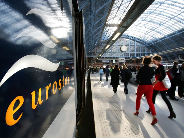 LONDON - NOVEMBER 14: Passengers walk alongside the first train to leave from the Eurostar platform at St Pancras International station on November 14, 2007 in London, England. The first public train to Paris pulled out of the station at 11.03 as St Pancras International Station began its Eurostar service. …