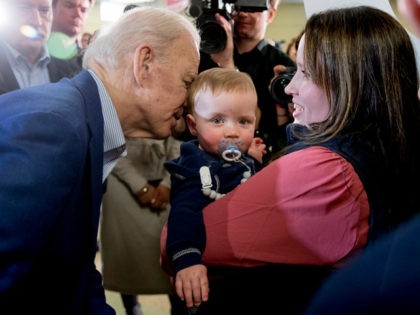 Democratic presidential candidate former Vice President Joe Biden whispers in the ear of a baby as he greets members of the audience at a campaign stop at Cilford Community Curch, Monday, Feb. 10, 2020, in Gilford, N.H. (AP Photo/Andrew Harnik)