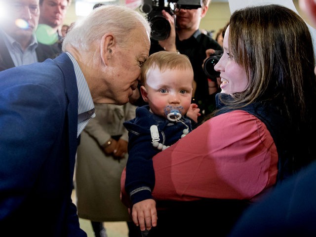 Democratic presidential candidate former Vice President Joe Biden whispers in the ear of a