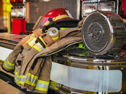 Firefighter protection gear on the fire truck bumper - stock photo