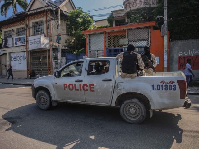 Armed police ride in the back of a truck after the streets of the Haitian capital Port-au-