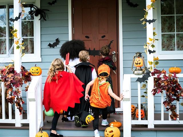 Young kids trick or treating during Halloween - stock photo