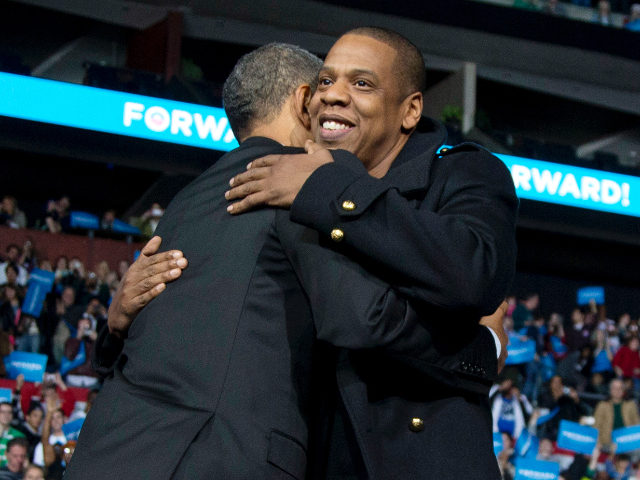 President Barack Obama is hugged on stage by musician Jay-Z, center, as musician Bruce Spr