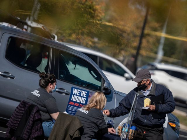 Recruiters speak with a potential applicant during a tail gate job fair in Leesburg, Virginia on October 21, 2021. - Initial applications for US jobless aid dipped again last week, falling to a new pandemic low, according to government data released on October 21. New unemployment claims fell 6,000 to …