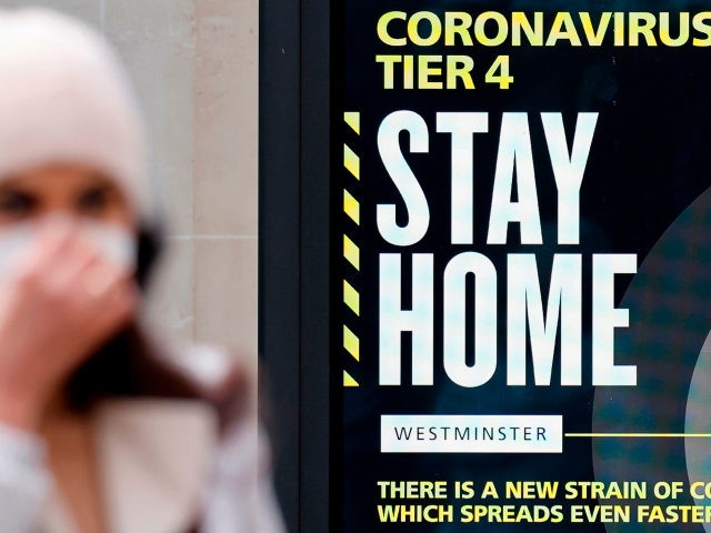 A pedestrian wearing a face mask or covering due to the COVID-19 pandemic, walks past a sign alerting people that "COVID-19 cases are very high in London - Stay at Home", in central London on December 23, 2020. - Britain's public health service urged Prime Minister Boris Johnson on Wednesday …
