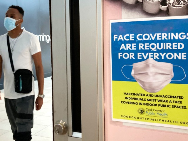 An information sign is displayed at a department store in Rosemont, Ill., Thursday, Aug. 26, 2021. Gov. J.B. Pritzker of Illinois announced on Thursday a new, stricter set of coronavirus restrictions, ordering a statewide indoor mask mandate and requiring that all educators be vaccinated or face regular testing. (AP Photo/Nam Y. Huh)