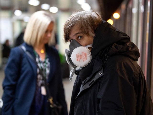 LONDON, ENGLAND - MARCH 23: A Commuters wearing a face protection mask travels on the unde